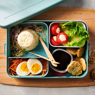 Oosterse bentobox met rijst, ei en sojadip